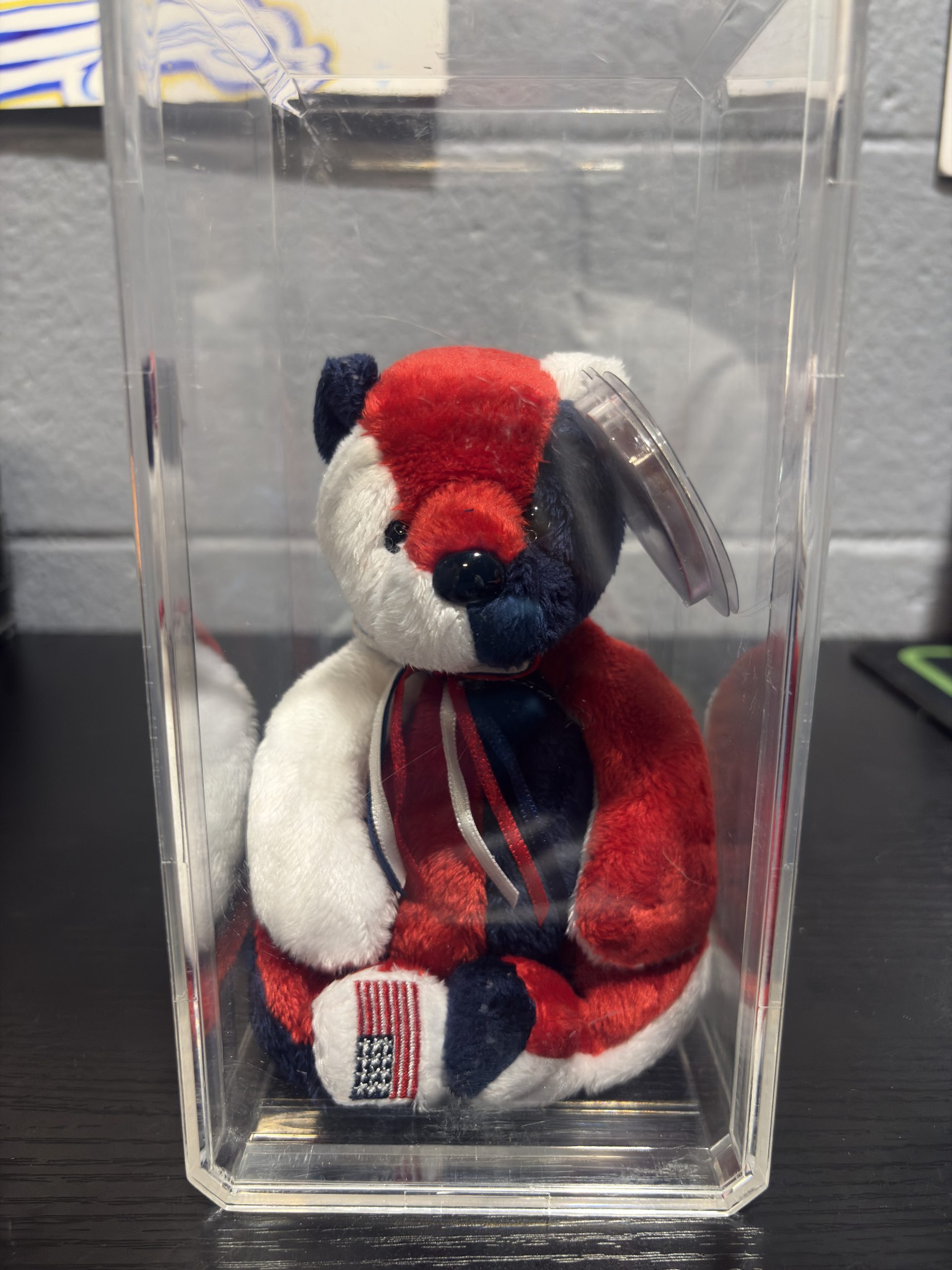 Ty Beanie Baby Patriot red white and blue patchwork bear with heart tag in clear display cylinder.