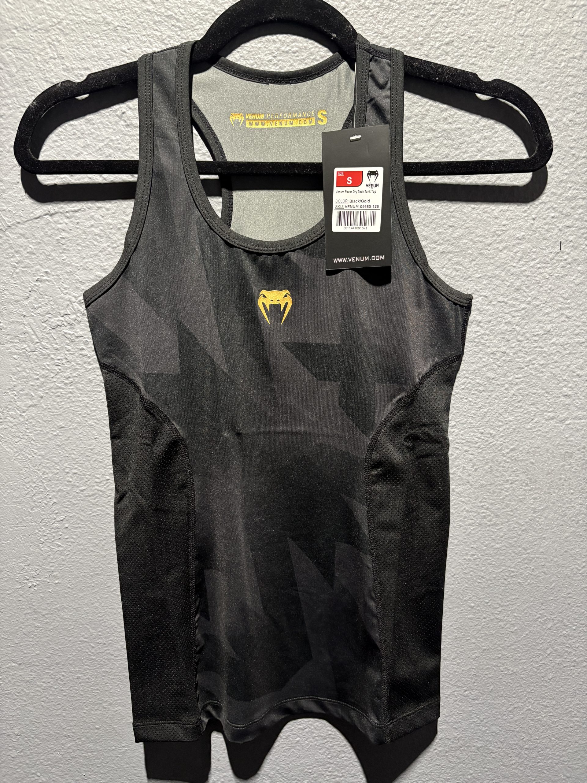 Venum Razor Dry Tech Tank Top in Black and Gold showing the chest logo, tag, and racerback collar in size S.