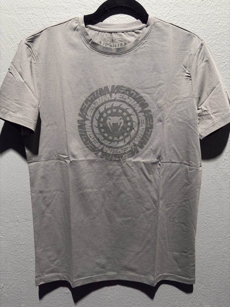 Venum Graphic T-Shirt in Grey showing the center chest circular logo and printed neck label in size M.