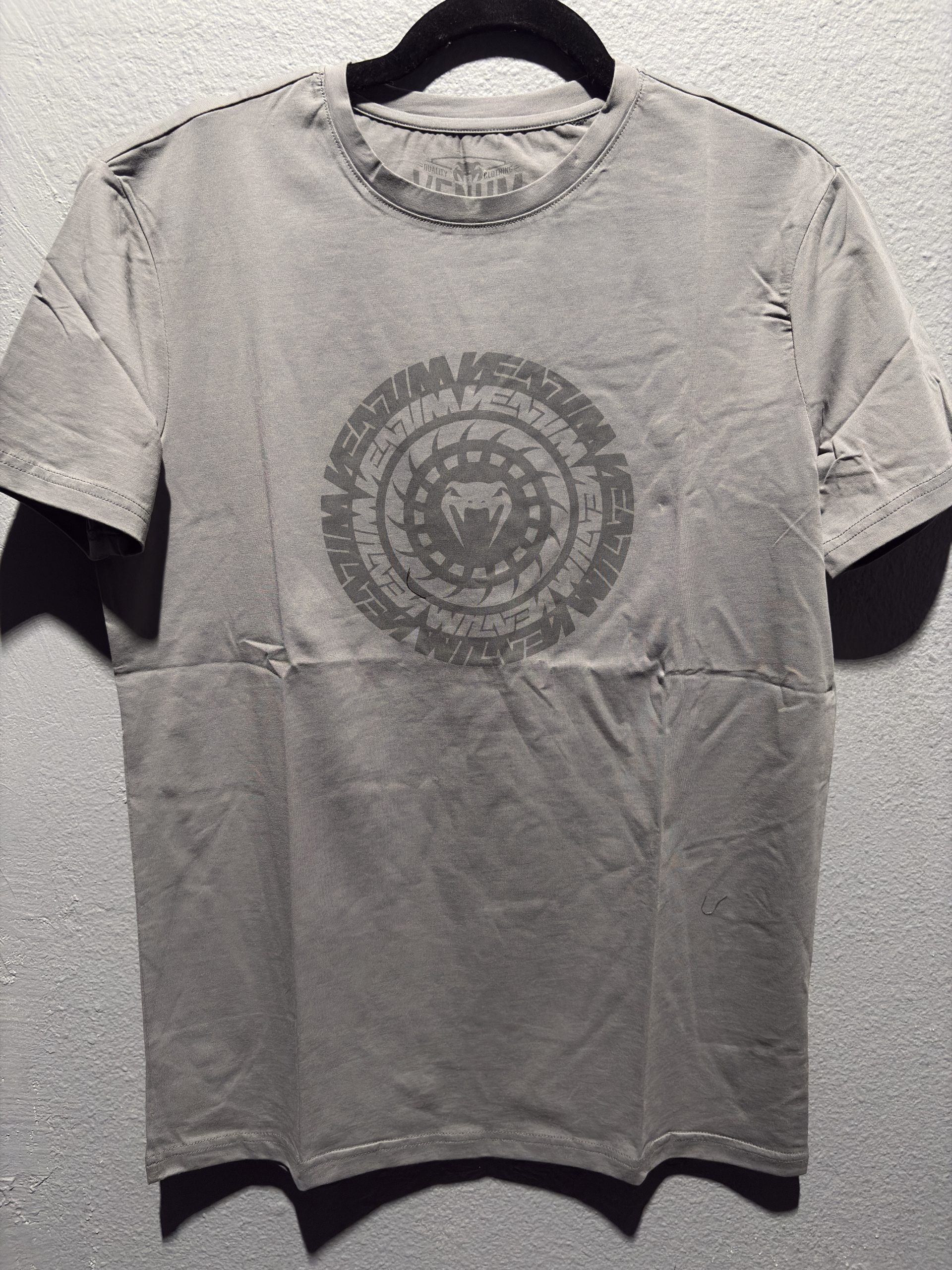 Venum Graphic T-Shirt in Grey showing the center chest circular logo and printed neck label in size M.