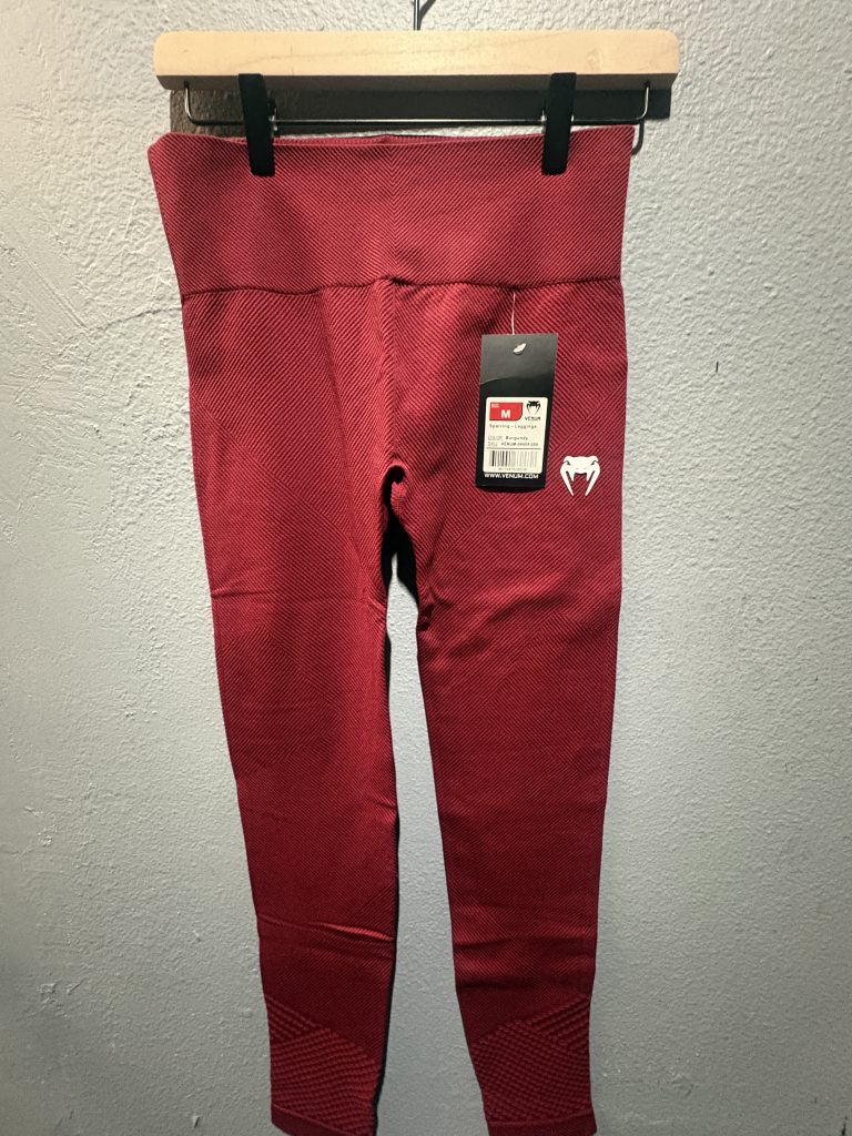 Venum Sparring Leggings in Burgundy showing the textured ribbed fabric, white logo, and hanging tag in size M.