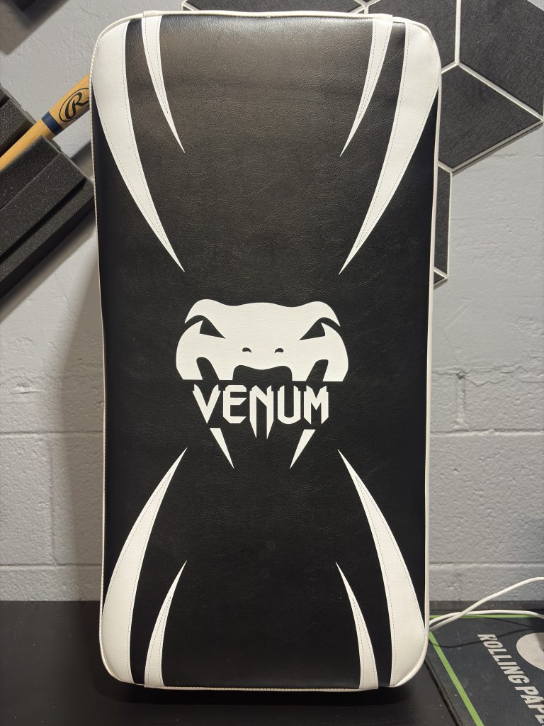 Venum Absolute Long Kick Shield in Black and Ice showing the front logo design and hanging retail tag.