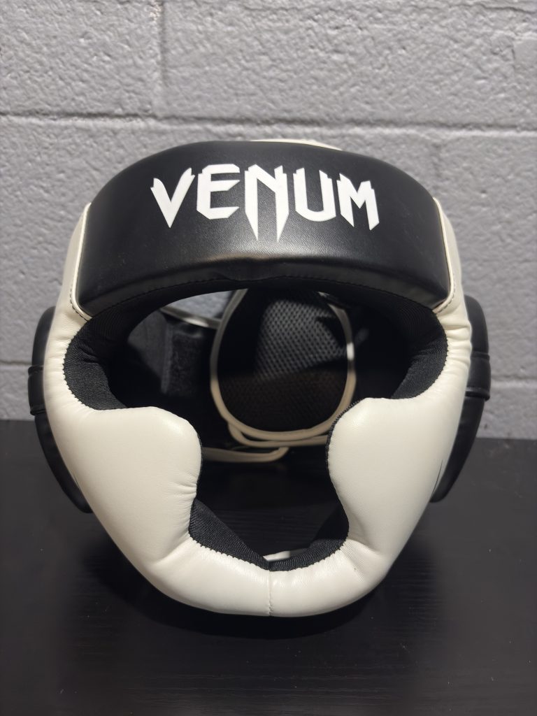 Venum Challenger 2.0 Headgear in Black and Ice showing the front forehead logo, ear protection, and hanging retail tag.