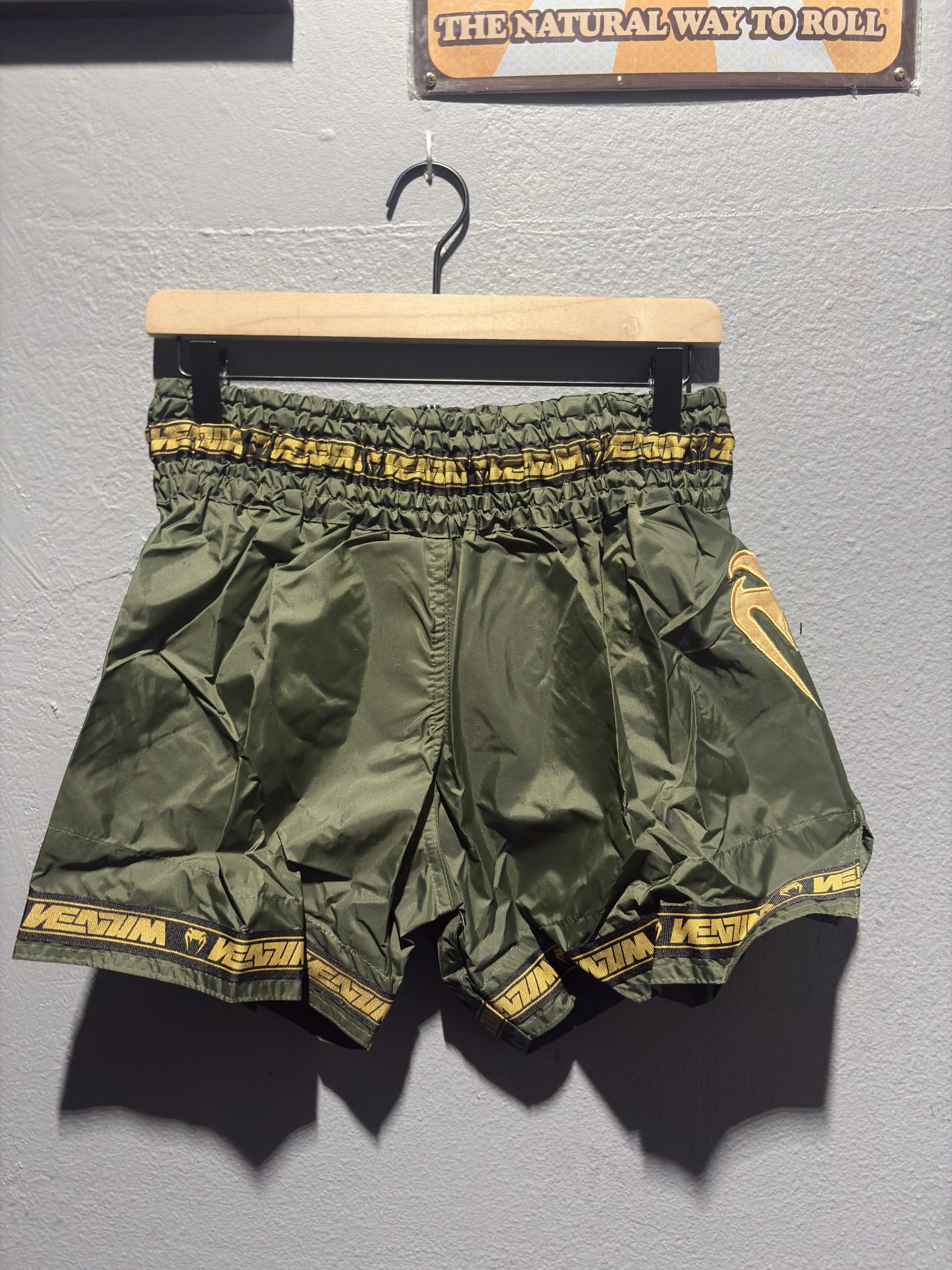 Venum Parachute Muay Thai Shorts in Khaki and Gold showing the elastic waistband, brand tag, and side logo in size XL.