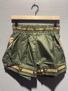 Venum Parachute Muay Thai Shorts in Khaki and Gold showing the elastic waistband, brand tag, and side logo in size L.
