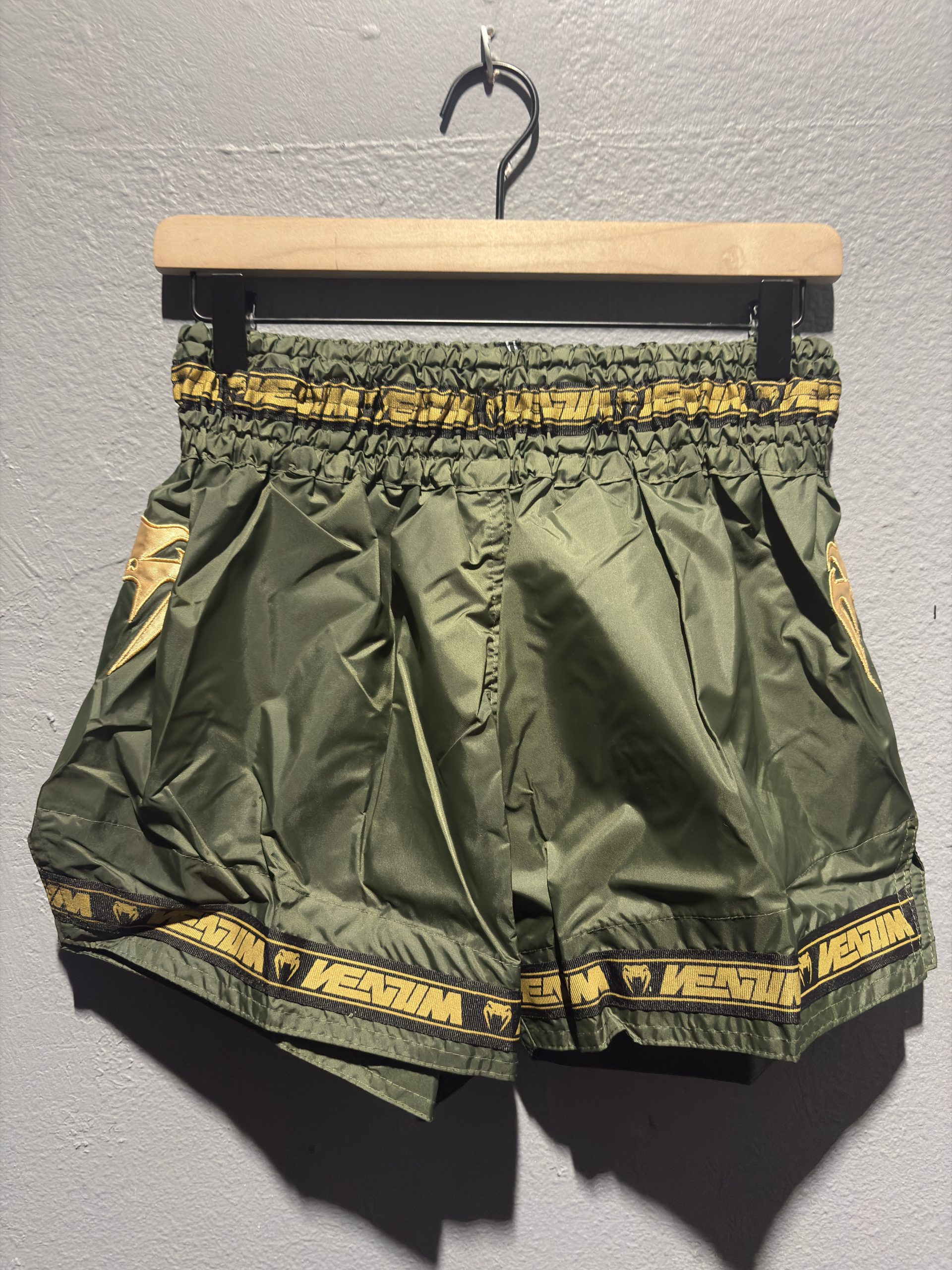 Venum Parachute Muay Thai Shorts in Khaki and Gold showing the elastic waistband, brand tag, and side logo in size L.
