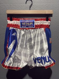 Venum MT Flags Muay Thai Shorts in USA Flag showing the waistband label, patriotic satin design, and retail tag in size L.