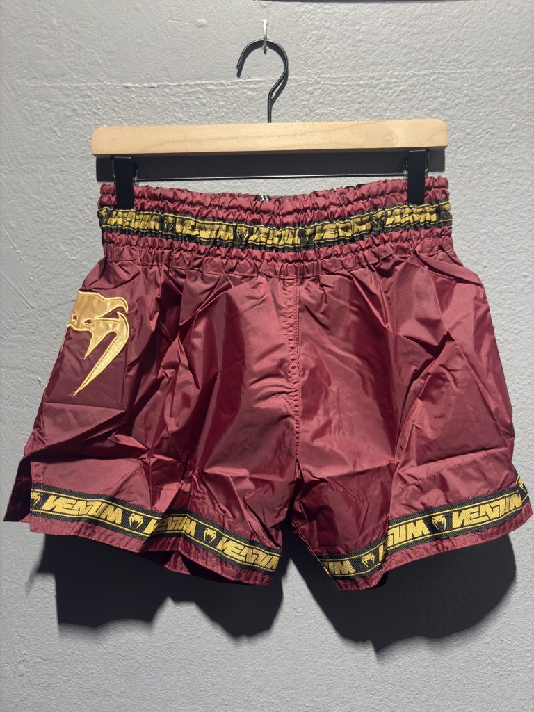 Venum Parachute Muay Thai Shorts in Burgundy showing the elastic waistband, brand tag, and side logo in size XL.