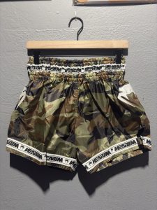 Venum Parachute Muay Thai Shorts in Forest Camo showing the elastic waistband, brand tag, and side logo in size L.