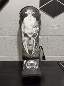 Venum GLDTR 4.0 Shin Guards in Black and White showing the gladiator graphic design and retail tag in size XL.