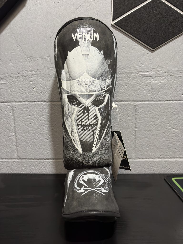 Venum GLDTR 4.0 Shin Guards in Black and White showing the gladiator graphic design and retail tag in size XL.