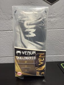 Venum Challenger 3.0 Boxing Gloves in Black and White shown inside their retail box and with a hanging size tag for 10oz.